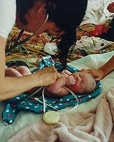 midwife checking newborn's heartbeat